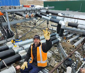 Expeditioner with big smile outside working on pipes