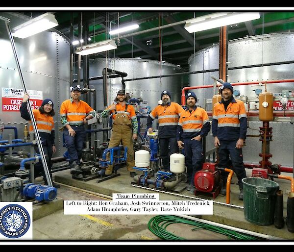 5 plumbers stand in front of water tanks for the inaugural plumber photo