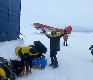 an excited expeditioner prepares for the marathon with basler airdraft parked on snow in the background