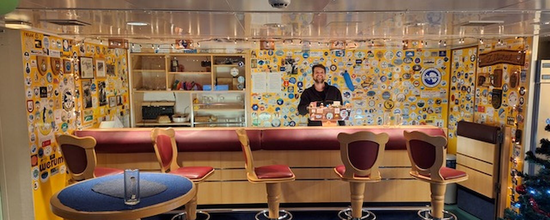 A bar with bar stools and memorabilia on the while behind