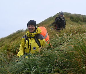 A woman in yellow expeditioner gear smiles at the camera.