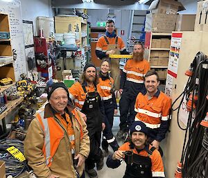 Seven Casey station electricians pose for a photo in workshop