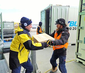 Expeditioners get packaged frozen food out of a refrigerated container near the Green Store.