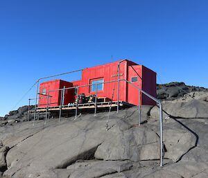 A red hut perched on a big rock