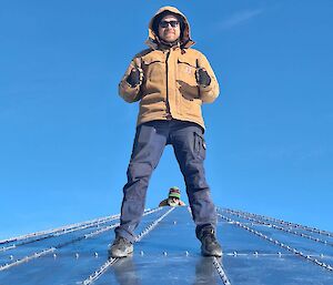 Guy standing on the top of the new water tank at Davis