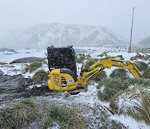 An excavator in the snow on the beach