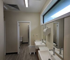 A clean bathroom with two sinks and toilet
