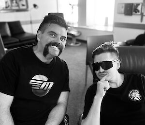 Two expeditioners with freshly cut hairstyles pose for a photo, in black and white
