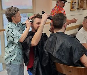 A hair cutting train, a expeditioner cutting hair whilst another expeditioner cuts the others hair