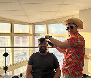 expeditioner Chris having his mullet shaved in, big smiles