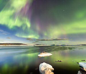 Yellow green reddish purple aurora above Horseshoe Harbour near Mawson on25 March 2024