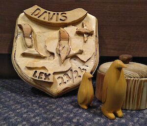 A wooden shield saying 'Davis' and 'Lex', two carved penguins and a wooden carved box