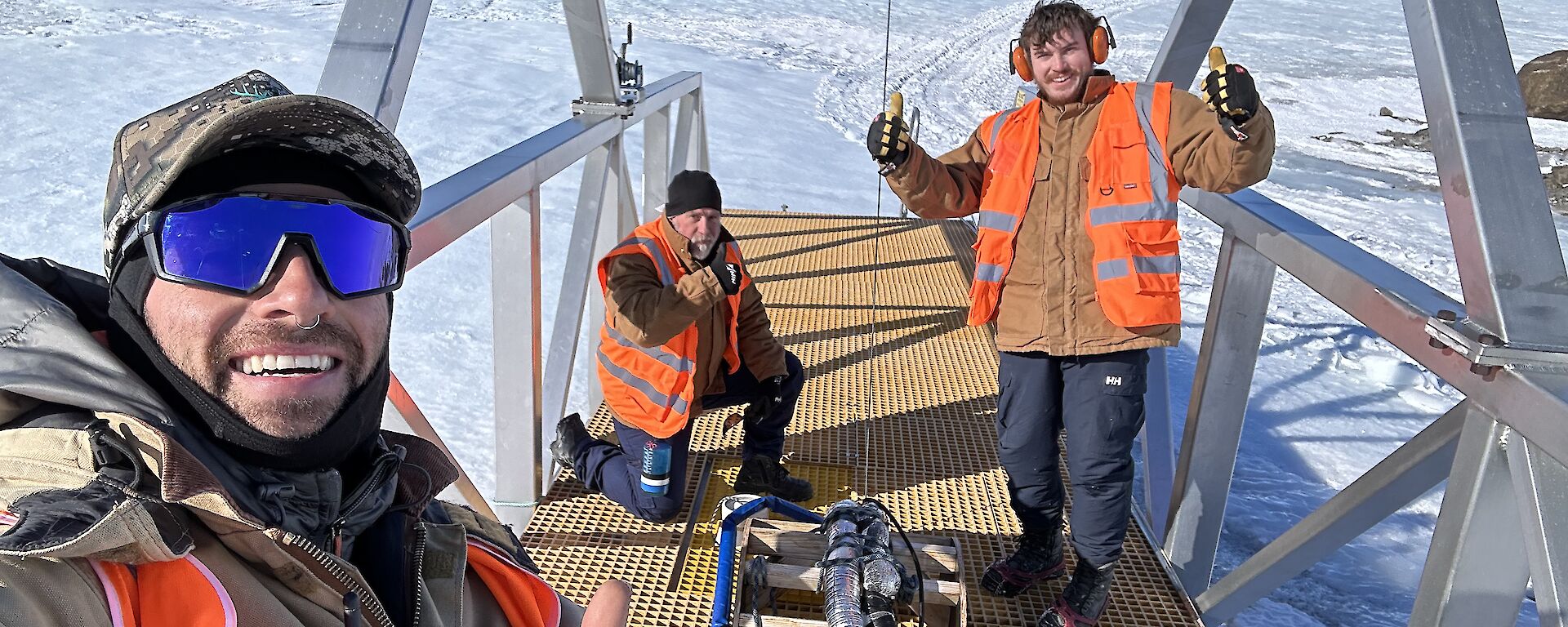 Three expeditioners, all plumbers, working on the bridge over the melt bell, used to extract fresh potable water for Mawson Research Station in East Antarctica