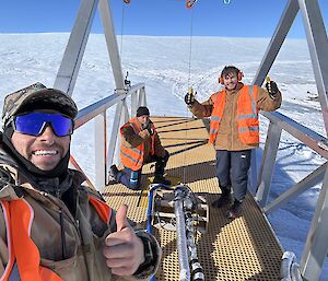 Three expeditioners, all plumbers, working on the bridge over the melt bell, used to extract fresh potable water for Mawson Research Station in East Antarctica