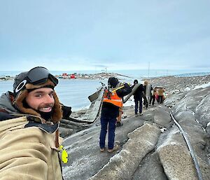 Ben, an expeditioner at Mawson, as he helps to carry a section of fuel line back to station recently