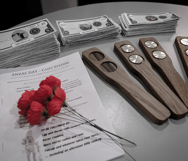 red poppies and fake money for playing the traditional two-up on a table