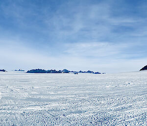 A vista in the Framnes Mountains with Hagglunds in the foreground on the icy plateau