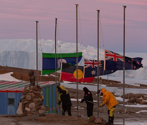 The flags for ANZAC day at half mast blowing in 30 knots with the plateau ice behind