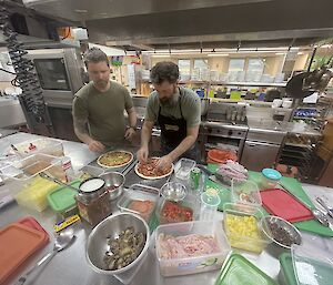 Adam and Aaron pictured making pizzas in the kitchen