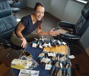 A woman sits at a table with a collection of satellite tags waiting to be deployed on skates.