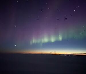 Aurora Australis with the sun twilight gradually dropping below horizon