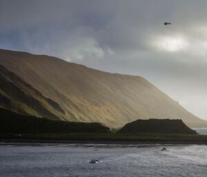 A LARC in the water and a helicopter in the air over Macquarie Island