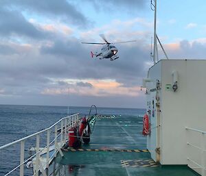 A helicopter prepares to land on the deck of RSV Nuyina