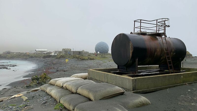 A rusty old fuel tank on a grey beach