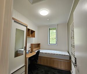A bright recently renovated bedroom, dark grey carpet and white walls.