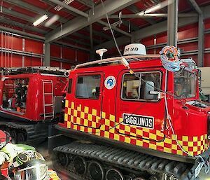 The red fire Hagglunds in the Emergency Vehicle Shelter (EVS) at Mawson station.