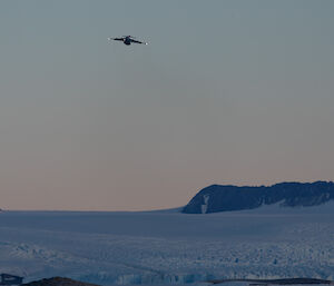 The C-17A turns towards Kista Strait in the front of Mawson Station to begin the airdrop