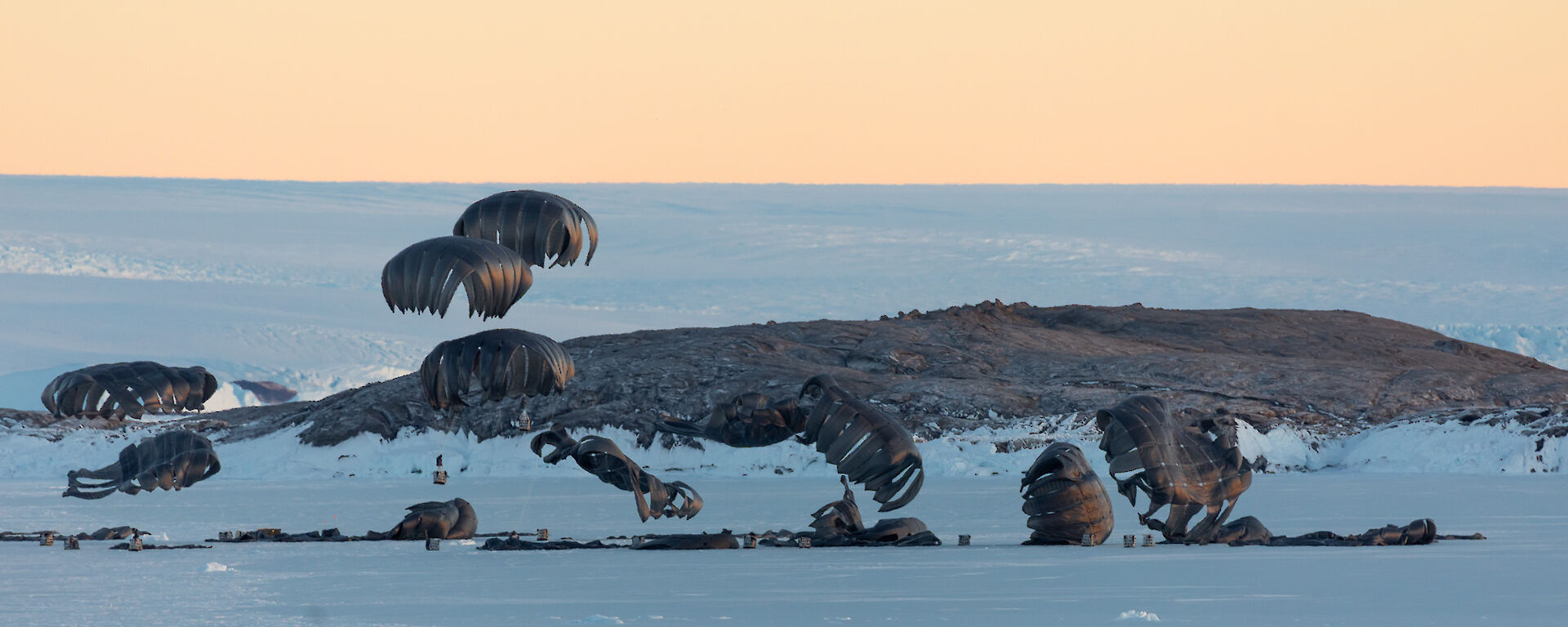 The parachutes gently touch down and deflate on the sea-ice in Kista Strait, in front of Mawson research station