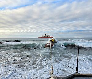 surf in the foreground, a red ship in the background