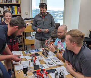 Expeditioners gathered around a table purchasing greeting cards in time for the christmas mailbag