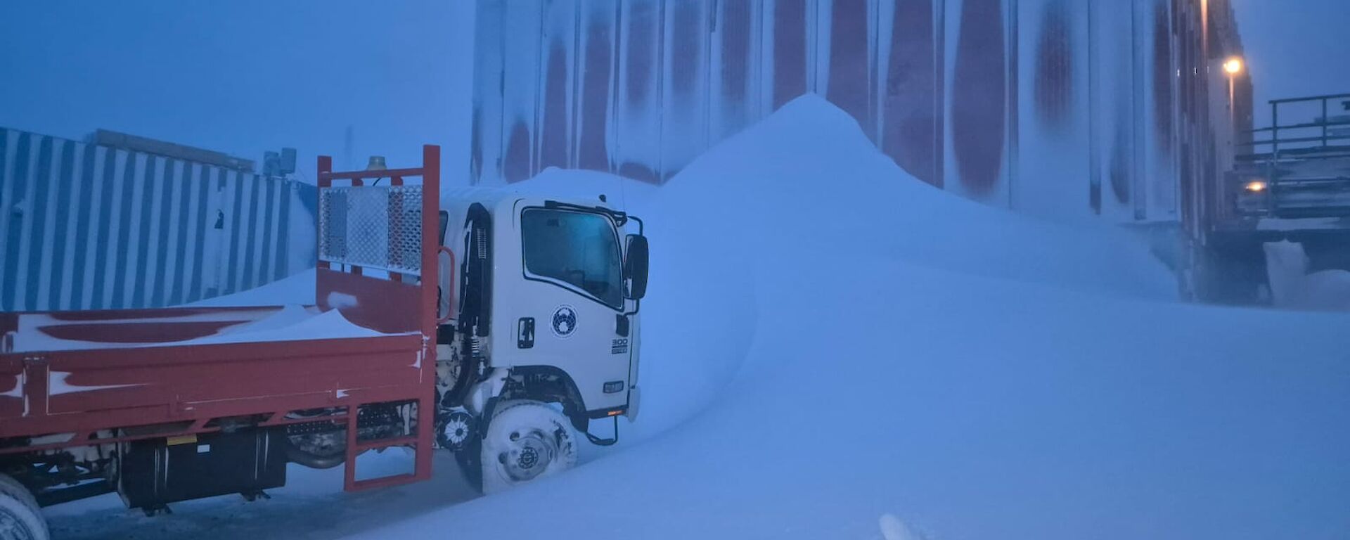 The Isuzu truck creating a lea for the driving snow of a blizzard at Mawson station this week