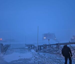 An expeditioner walking to the Red shed in blizzard conditions