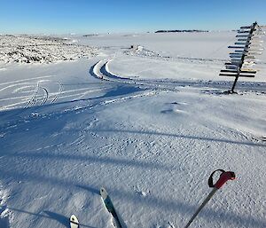 View of flat, snow-covered terrain, from the perspective of a person with skis on.