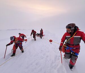 6 team members attach ropes to the pontoon individually via their harness to collectively pull the pontoon to shore