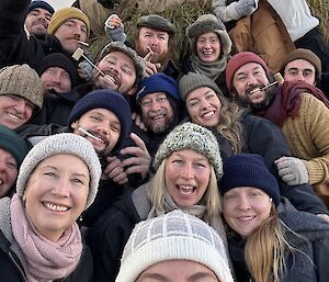 A selfie with 20 expeditioners in the group, all dressed to look like early expeditioners in woollen jumpers and beanies, smiling to camera