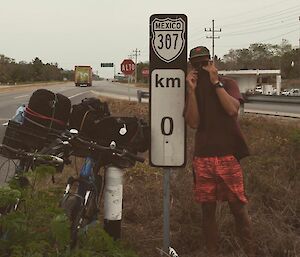 mitch infront of a state sign with bikes during travels in mexico
