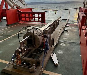 A four-metre long metal tube with a weight at one end, used to collect ocean sediment cores, sitting on the aft deck of Nuyina.