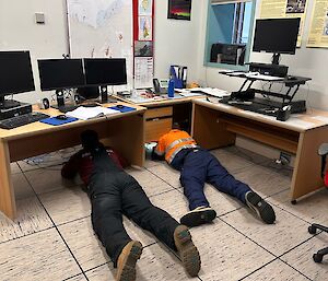 Two expeditioners on the floor trying to fix something electrical