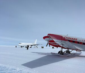A A319 snow bird plane and Chinare light winged plane sit on the ice runway