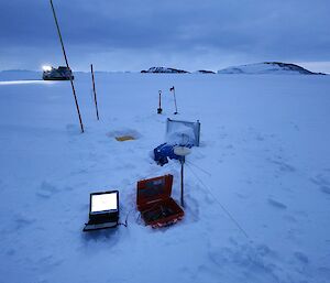 A laptop and electronics equipment sit on a snowy landscape