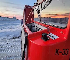 A red hagland truck, side view, on snow