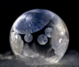 Frosty patterns on a soap bubble light from behind with a torch