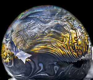 A soap bubble with swirling patterns prior to freezing
