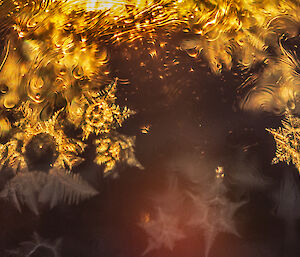 Sunlight behind a round bubble highlights snowflake patterns on its surface