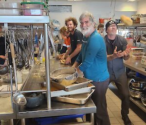 A group of people stand around in the station kitchen