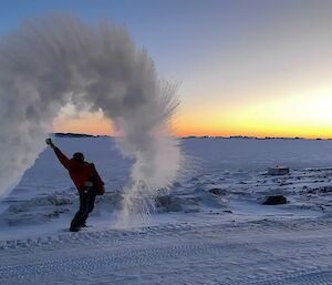 A person throws water into the air and it freezes, forming a jagged cloud